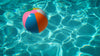 Colorful Beach Ball Floating In Sparkling Clean Pool