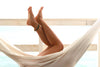 Woman Laying In Cloth Hammock With Smooth Legs Up In The Air