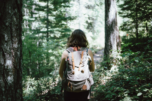 Woman Hiking With Backpack Through Woods Prepared For Survivial With Tampons