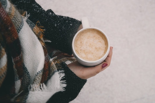 Woman Cozy Out In The Snow Holding A Hot Drink To Snuggle Up With